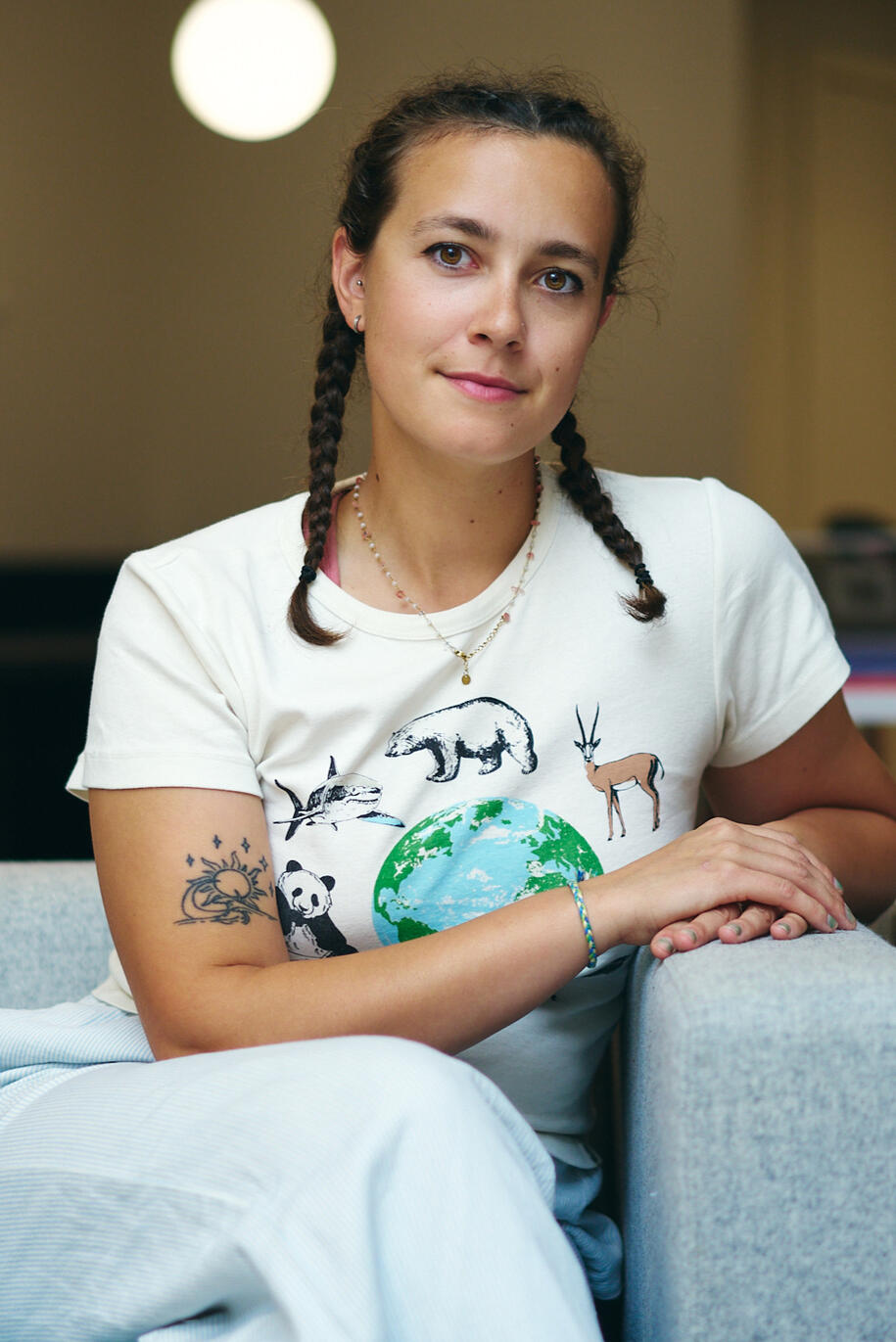 Indiemoon Illustrator Indiemoon the illustrator sits in a chair with her hands cupping on the side of the chair